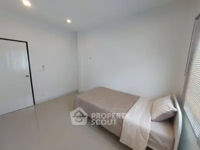 Minimalist bedroom with single bed and neutral decor, perfect for a cozy living space.