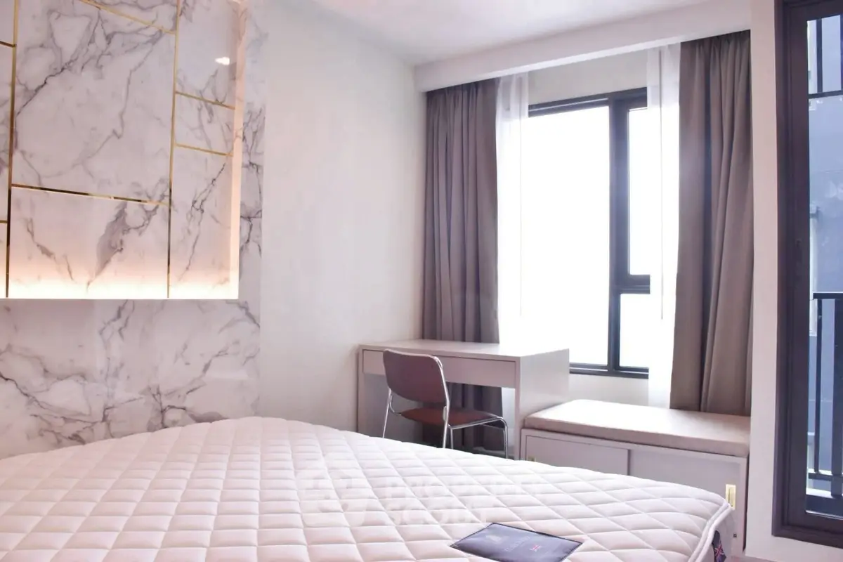 Modern bedroom with marble accent wall and large window for natural light.