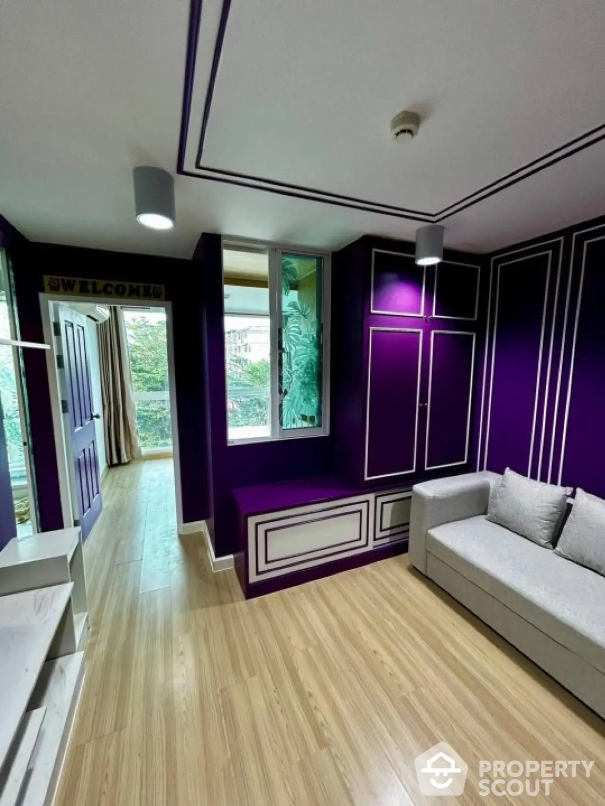 Stylish modern living room with vibrant purple accents and cozy seating area