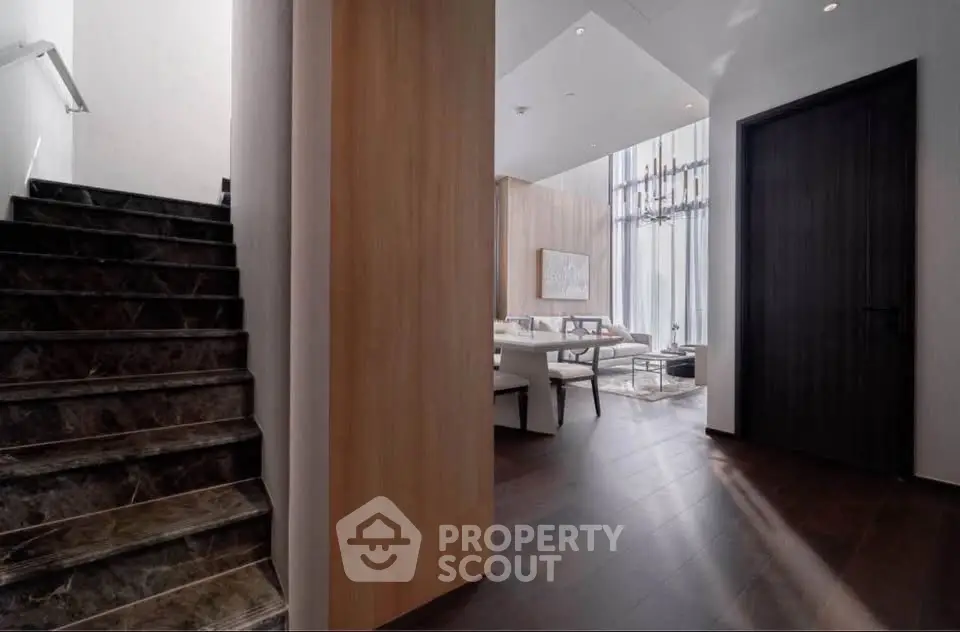 Luxurious modern interior with elegant staircase and spacious living area, featuring high ceilings and stylish decor.