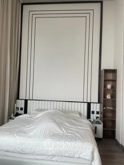 Luxurious modern bedroom with elegant wall design and cozy bedding