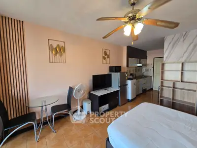Spacious studio apartment with modern decor and ceiling fan, featuring a kitchenette and cozy dining area.