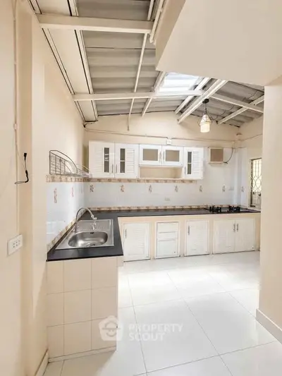 Bright kitchen with modern cabinetry and sleek countertops under a skylight.