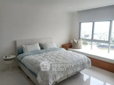 Bright and airy bedroom with large window and modern decor