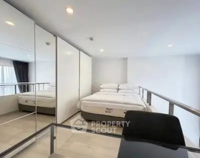 Modern bedroom with mirrored wardrobe and sleek design in a stylish apartment.