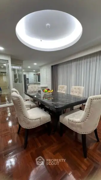 Elegant dining room with luxurious table and plush chairs, perfect for hosting gatherings.