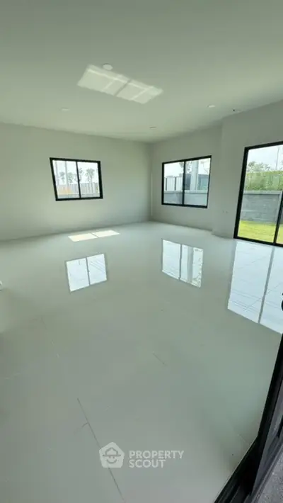 Spacious empty room with large windows and glossy tiled floor, perfect for customization.