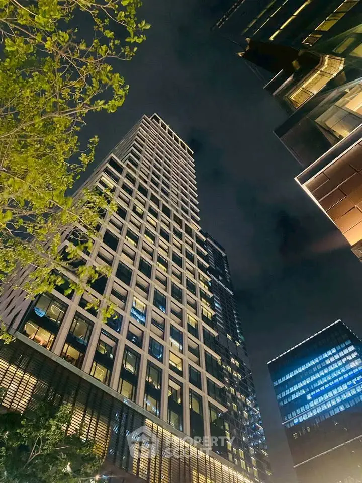 Stunning night view of modern high-rise building with illuminated windows and sleek architecture.
