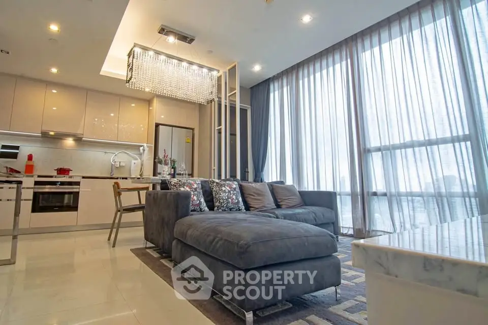 Luxurious modern living room with elegant chandelier and floor-to-ceiling windows