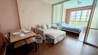 Modern studio apartment with open living and bedroom area, featuring stylish furniture and large windows.
