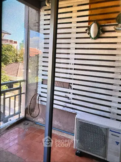 Charming balcony with air conditioning unit and privacy screen, perfect for relaxation.