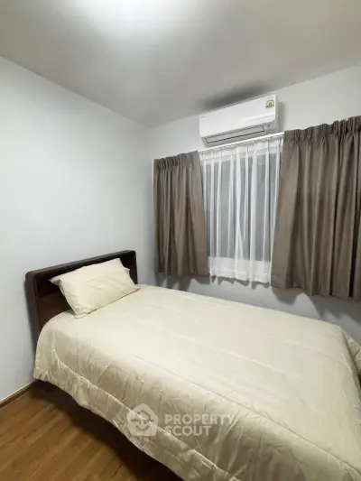 Cozy bedroom with single bed and air conditioning, perfect for a comfortable stay.