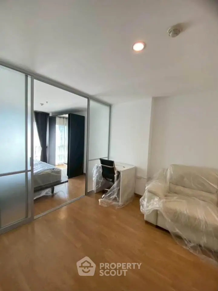 Modern apartment with sliding glass doors, cozy living area, and a study desk, perfect for urban living.