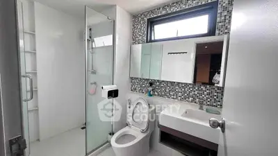 Modern bathroom with glass shower and stylish mosaic tiles