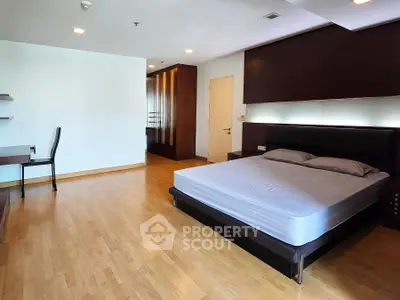 Spacious modern bedroom with wooden flooring and elegant furnishings