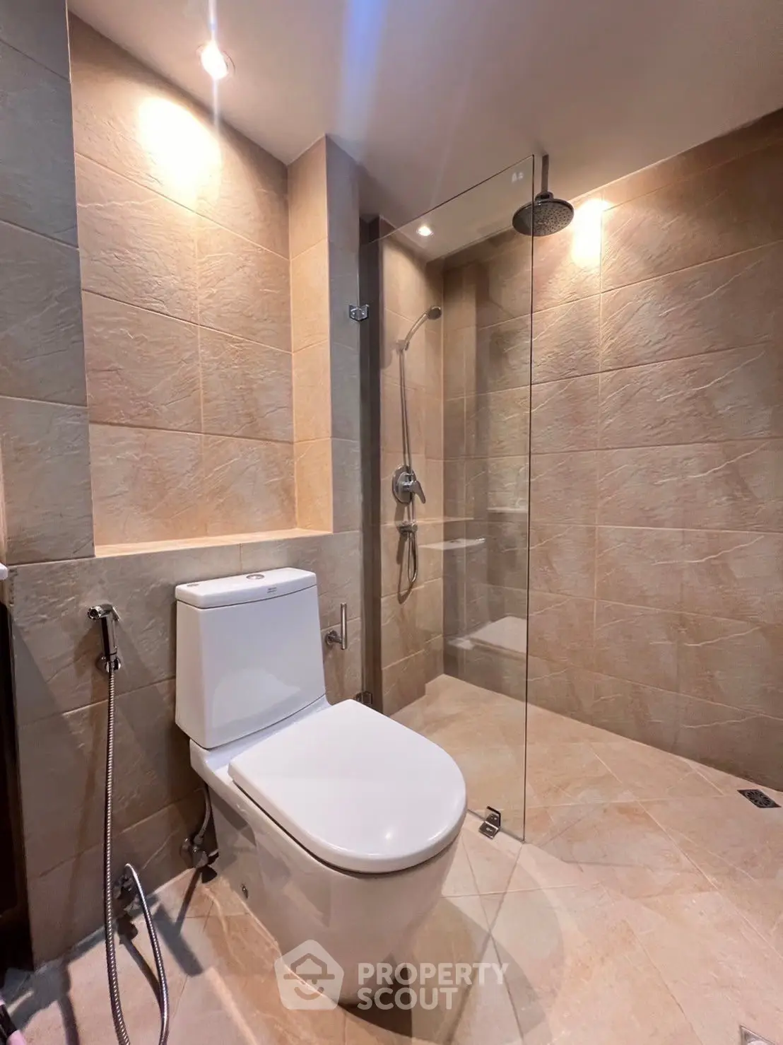 Modern bathroom with glass shower and sleek fixtures in neutral tones.