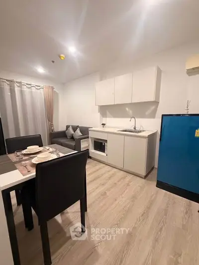 Modern open-layout kitchen and dining area with sleek furniture and appliances.