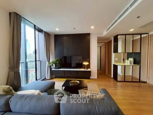 Modern living room with large windows and stylish decor in a high-rise apartment.