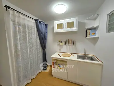 Charming compact kitchen with modern cabinetry and natural light