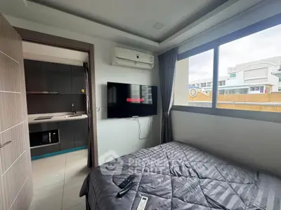 Modern bedroom with wall-mounted TV and large window offering natural light