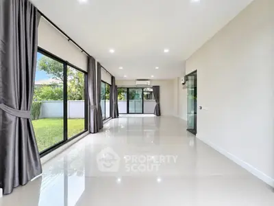 Spacious modern living room with large windows and garden view