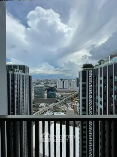 Stunning cityscape view from a high-rise balcony with modern skyscrapers and dramatic clouds.