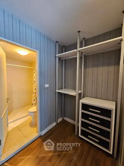 Compact bathroom with adjacent storage area featuring built-in shelves and drawers, ideal for efficient space utilization.