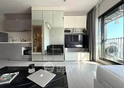 Modern living room with sleek design, mirrored cabinets, and balcony access.