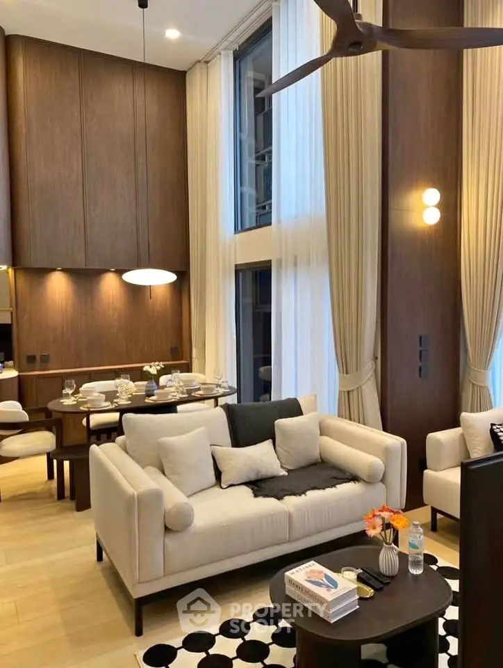 Luxurious living room with high ceilings, elegant decor, and modern furniture in a stylish apartment.
