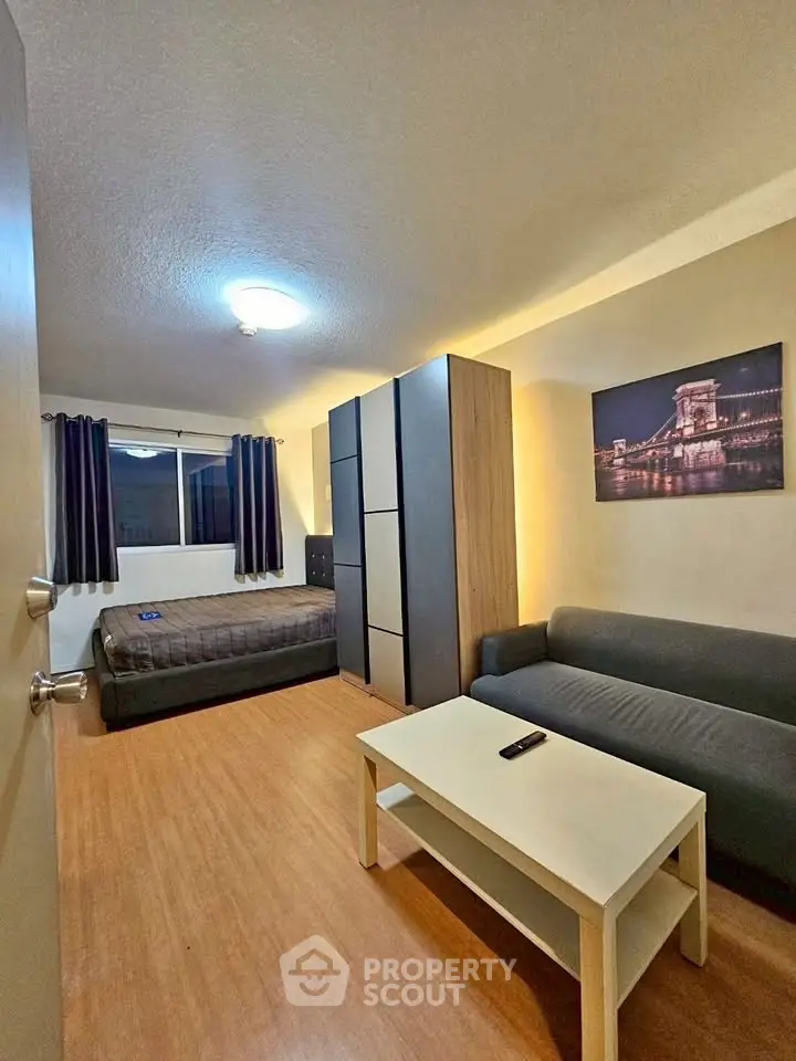 Cozy studio apartment with modern furnishings and wooden flooring.