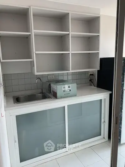 Compact kitchen with open shelving and sliding glass cabinets