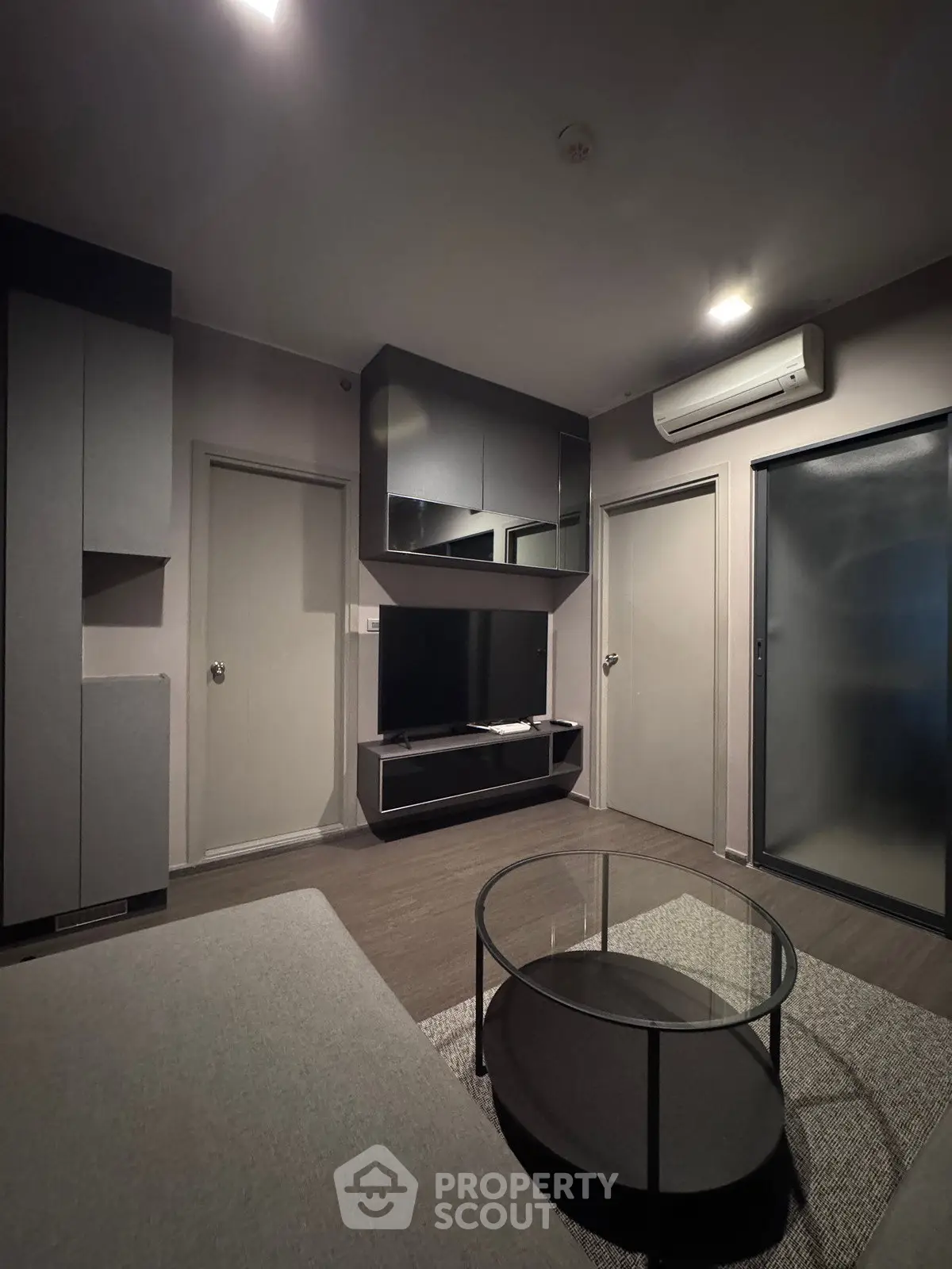 Modern living room with sleek furniture and wall-mounted TV in a stylish apartment.
