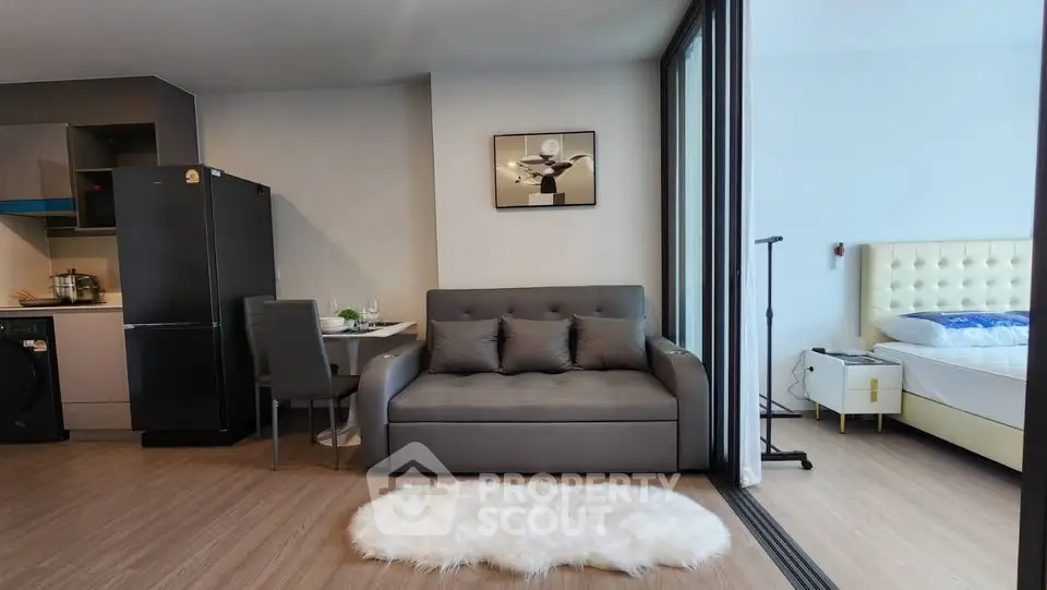 Modern open-plan living room with cozy sofa and stylish kitchen in a chic apartment.