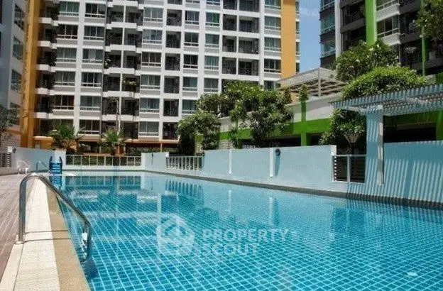 Luxurious apartment complex with a pristine swimming pool and modern architecture.