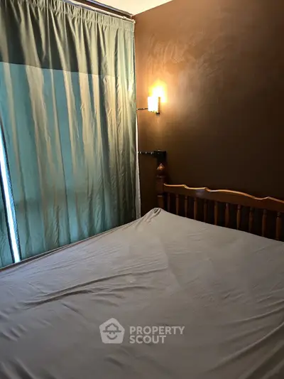 Cozy bedroom with wooden bed and soft lighting, perfect for relaxation.