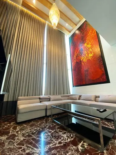 Luxurious living room with high ceilings, modern art, and elegant marble flooring.
