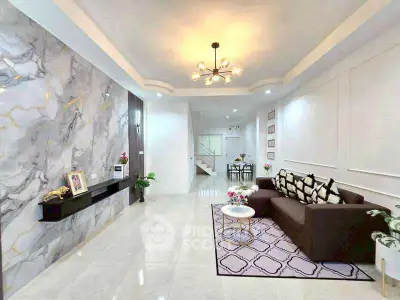Spacious modern living room with elegant marble accent wall and cozy seating area.