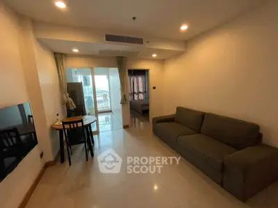 Spacious living room with modern sofa and dining area, featuring a balcony view.