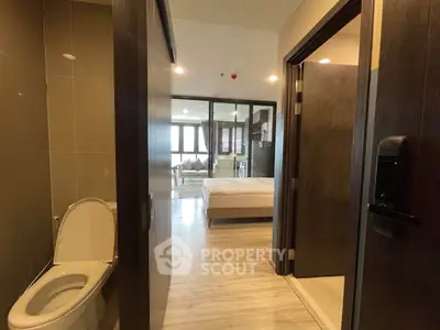 Modern apartment interior with bedroom and bathroom view, featuring sleek design and contemporary furnishings.