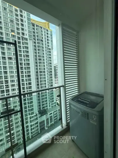 High-rise apartment balcony with washing machine and city view