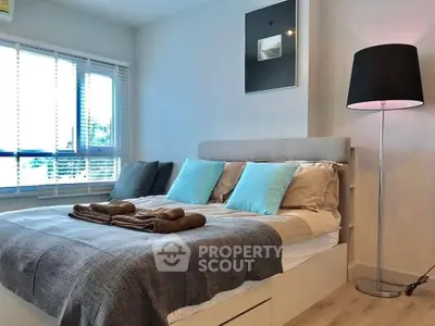 Inviting modern bedroom with a plush queen-sized bed, stylish floor lamp, and tranquil blue accents, perfect for a restful retreat in a contemporary home.