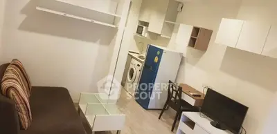 Modern compact apartment with open kitchen, washing machine, and cozy living area.