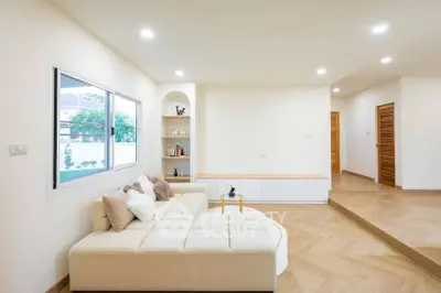 Spacious modern living room with cozy sectional sofa and elegant wooden flooring.