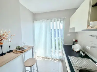 Bright kitchen with modern design and natural light, featuring sleek countertops and a cozy breakfast bar.