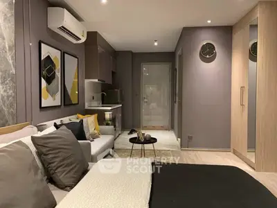 Modern studio apartment with stylish decor and compact kitchen in open layout