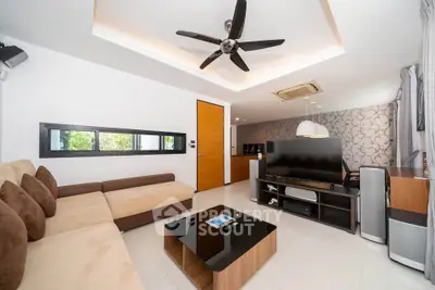 Modern living room with stylish decor and ceiling fan, featuring a cozy sectional sofa and entertainment center.