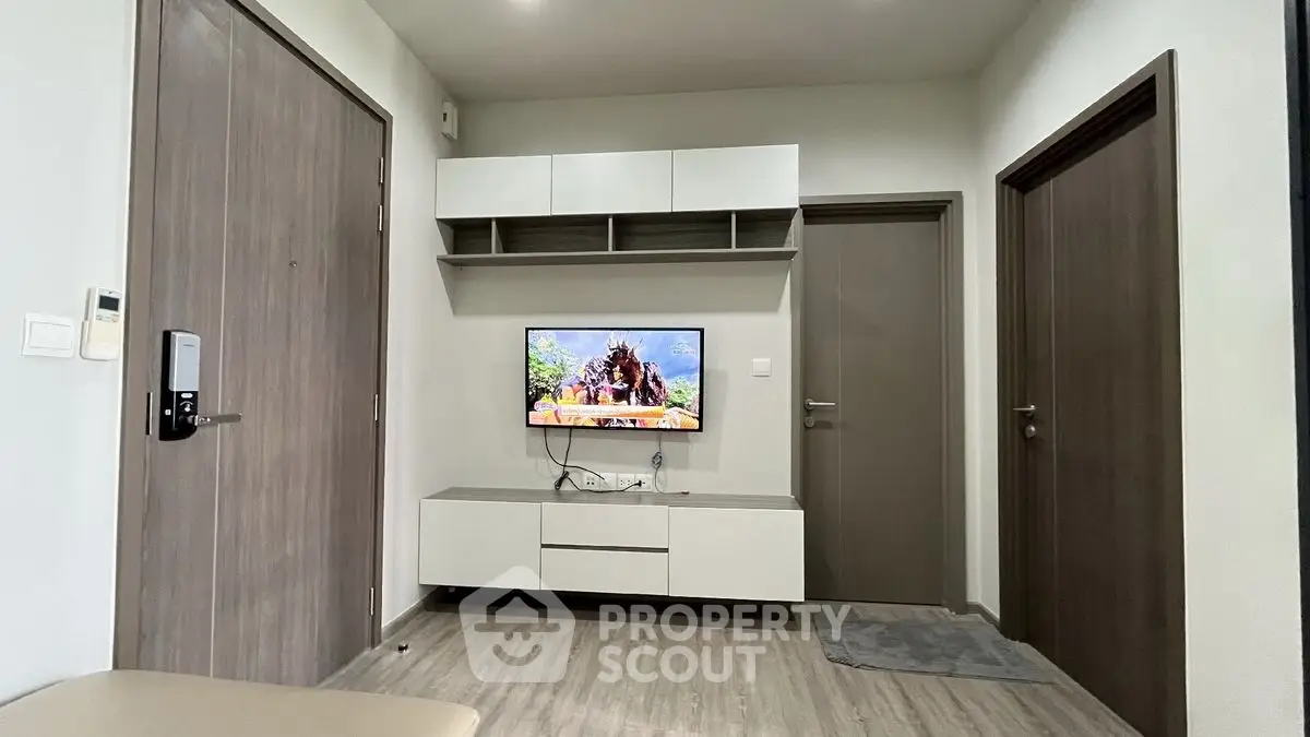 Modern living room with sleek TV unit and storage cabinets, featuring a minimalist design and neutral tones.