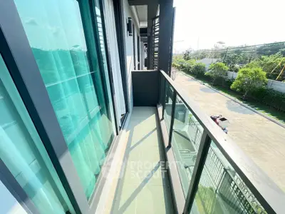 Modern apartment balcony with glass railing and street view