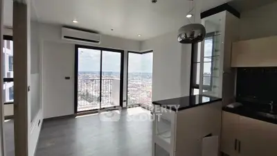 Spacious modern living room with balcony and city view in high-rise apartment.