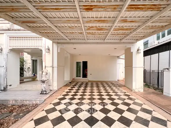 Spacious covered parking area with elegant checkered flooring in a modern home.
